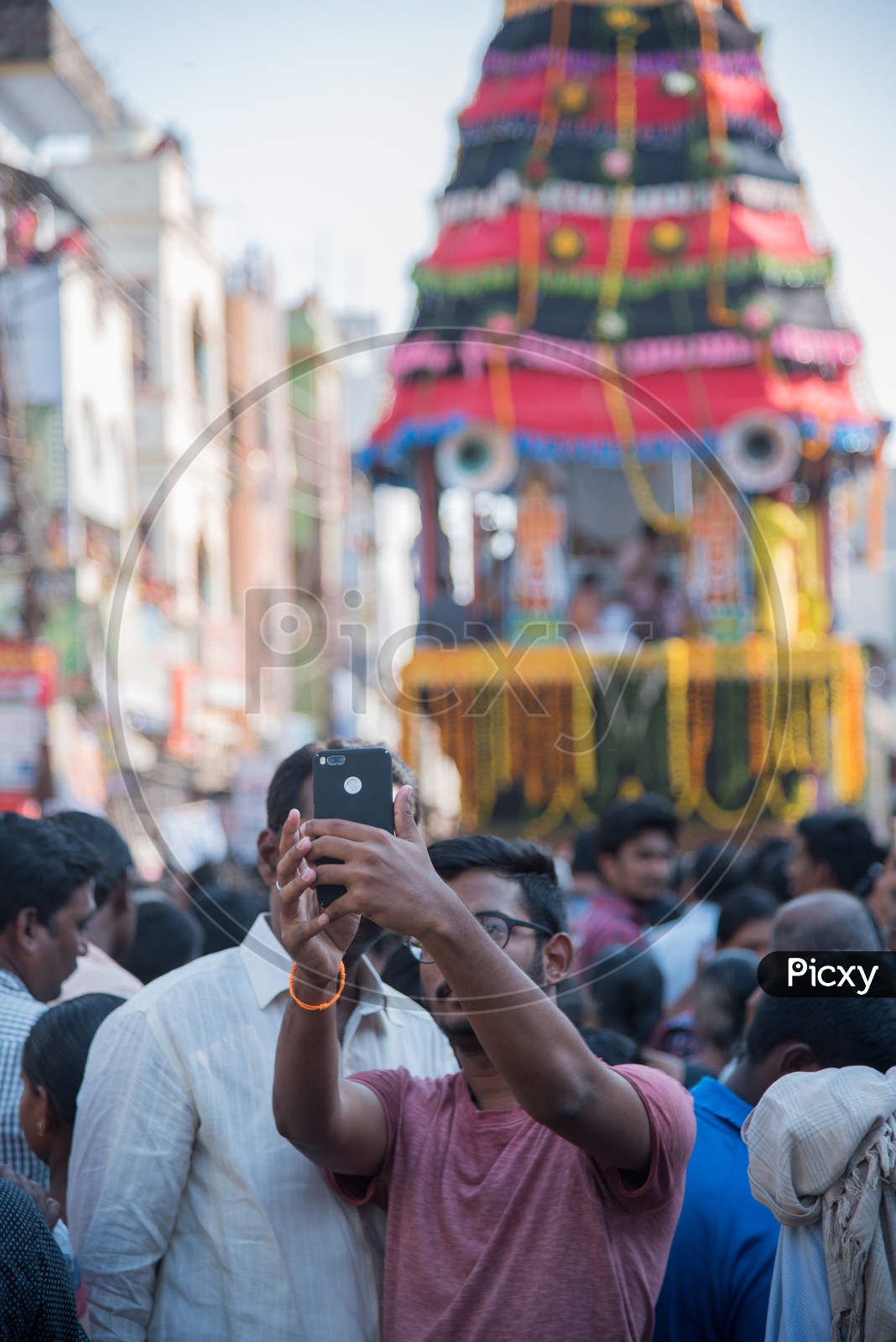 A father,son duo taking a selfie with Panakala Laxmi Narasimha Swamy Chariot in the Background