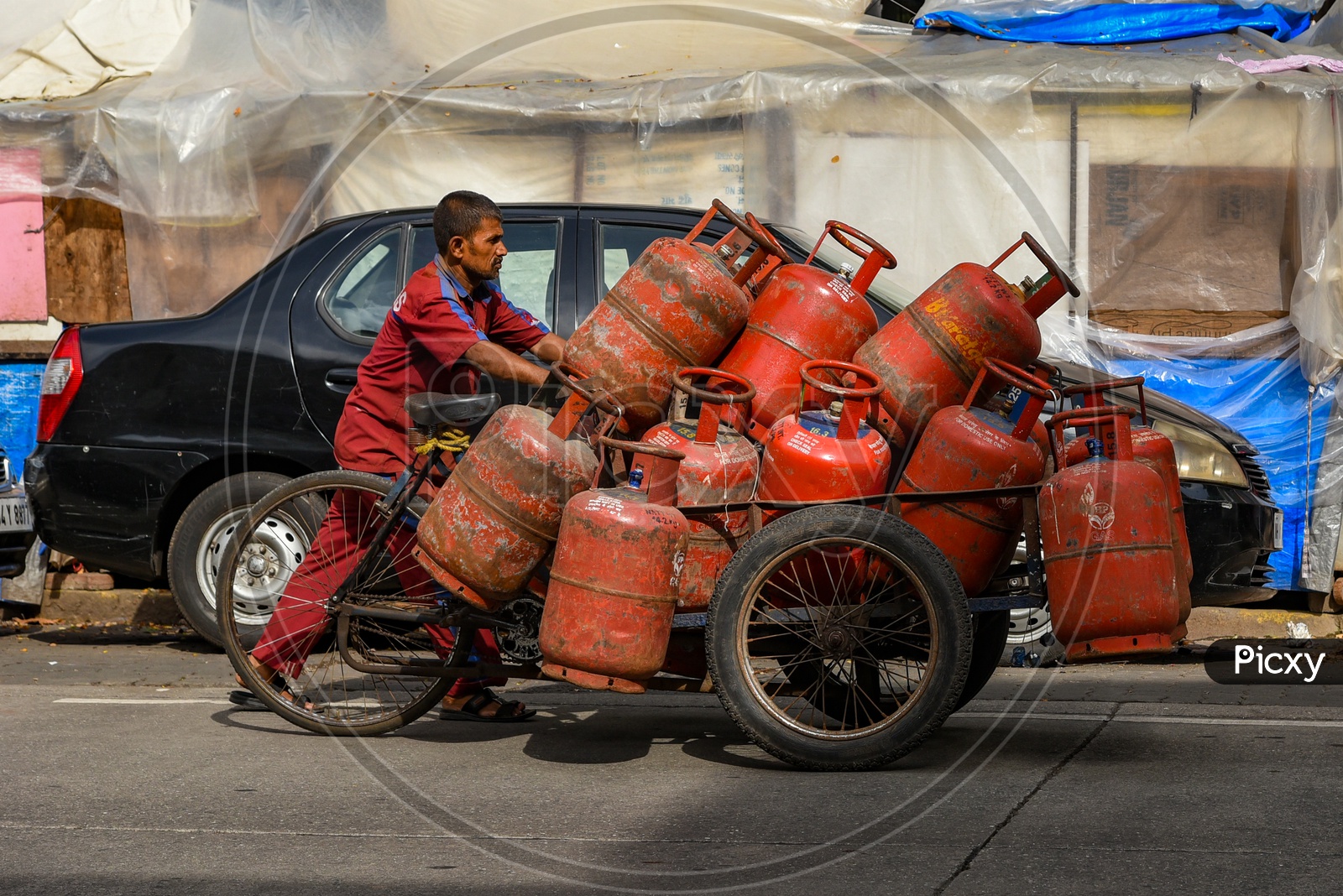 Gas cylinder delivery man uses hand pushed cart to distribute cylinders