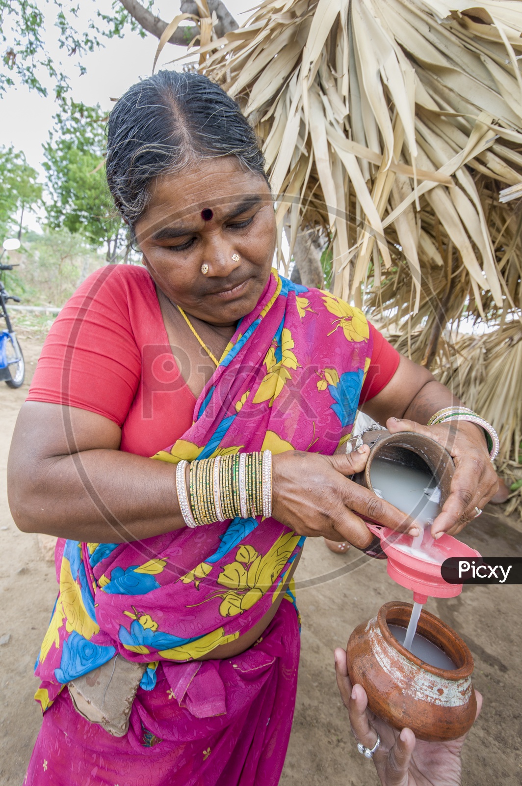 A lady pouring toddy