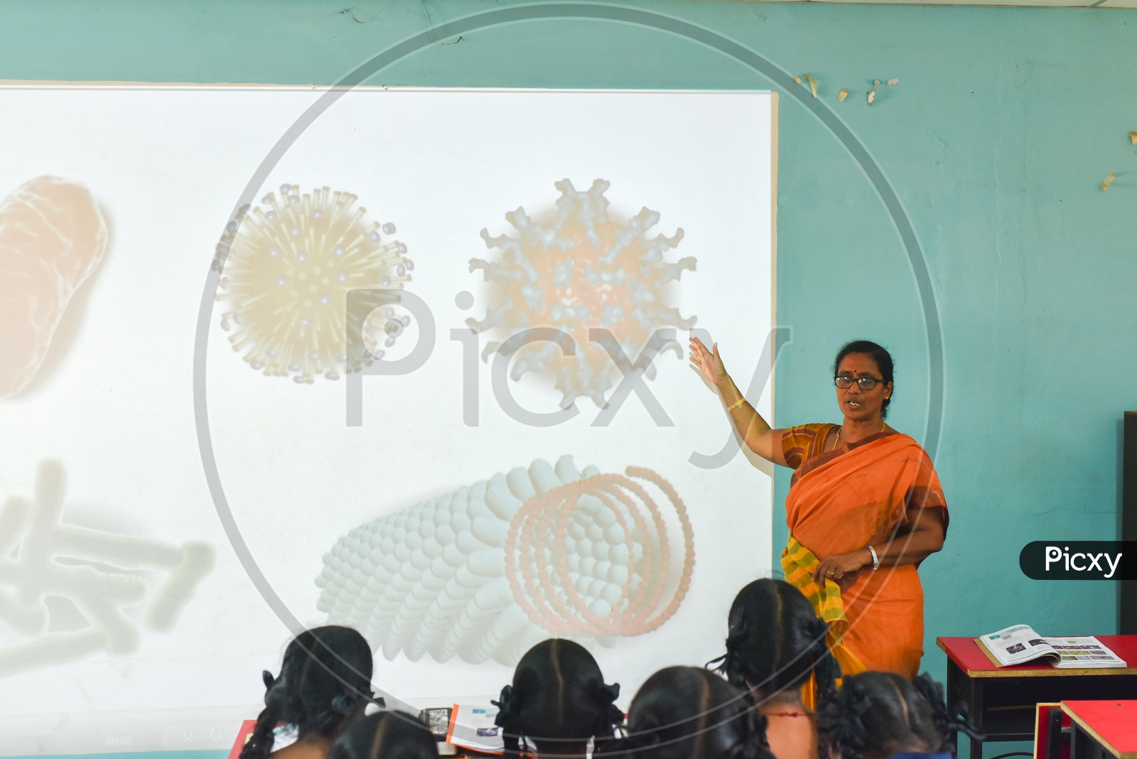 A teacher explaining taking a class on Virus through digital projections