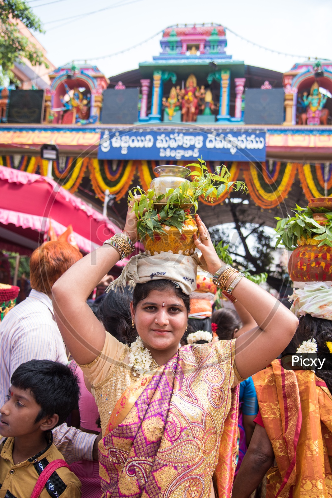 Woman carrying the Bonam pot for Bonalu Festival at Mahankali Temple