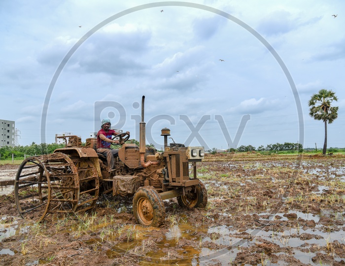 a farmer plowing/ploughing with a tractor