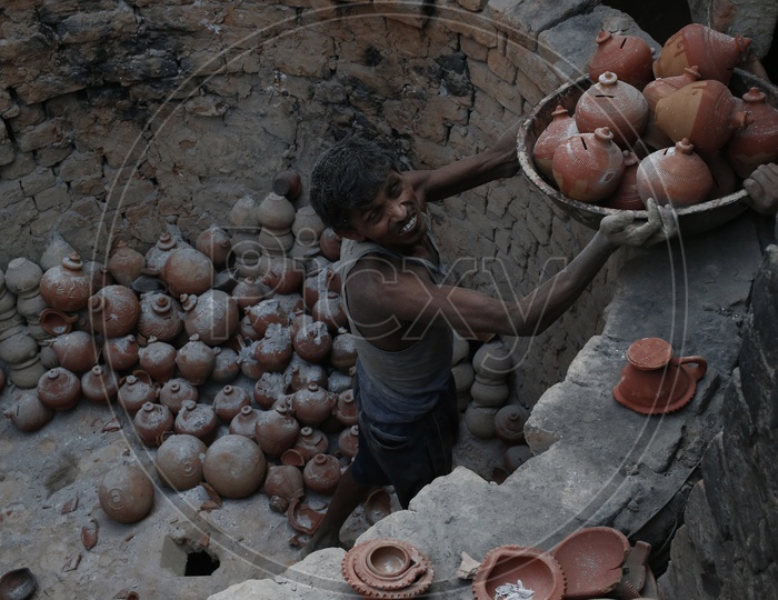 A worker makes clay piggy banks
