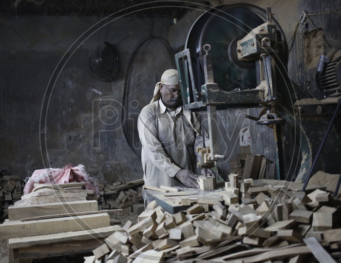 Worker cutting Wood using Machine