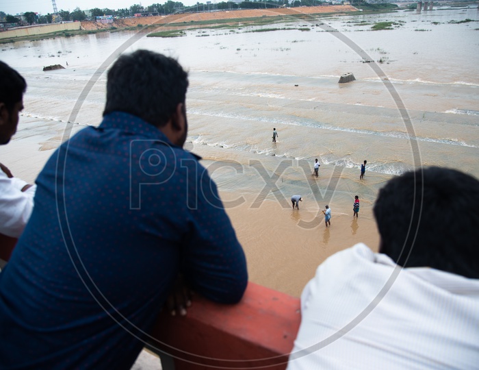 people watch fishermen fishing at Prakasam Barrage
