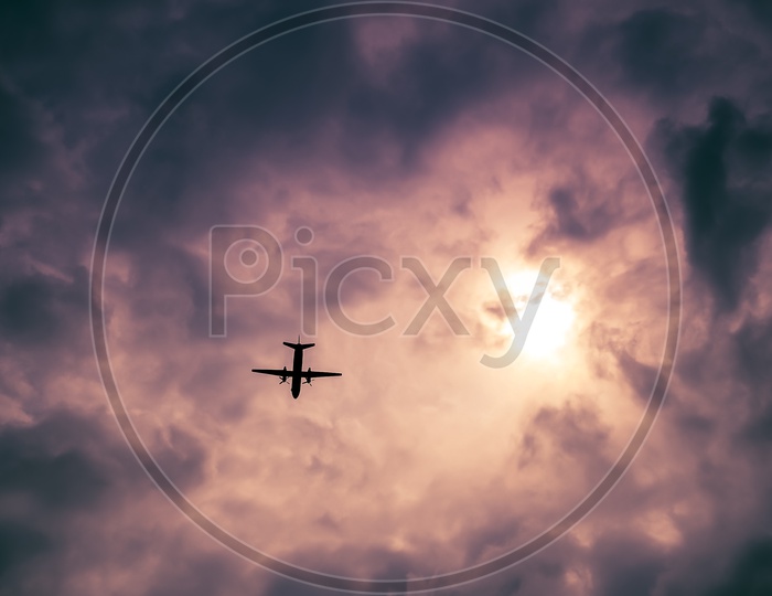 View of an airplane flying through clouds from rooftop