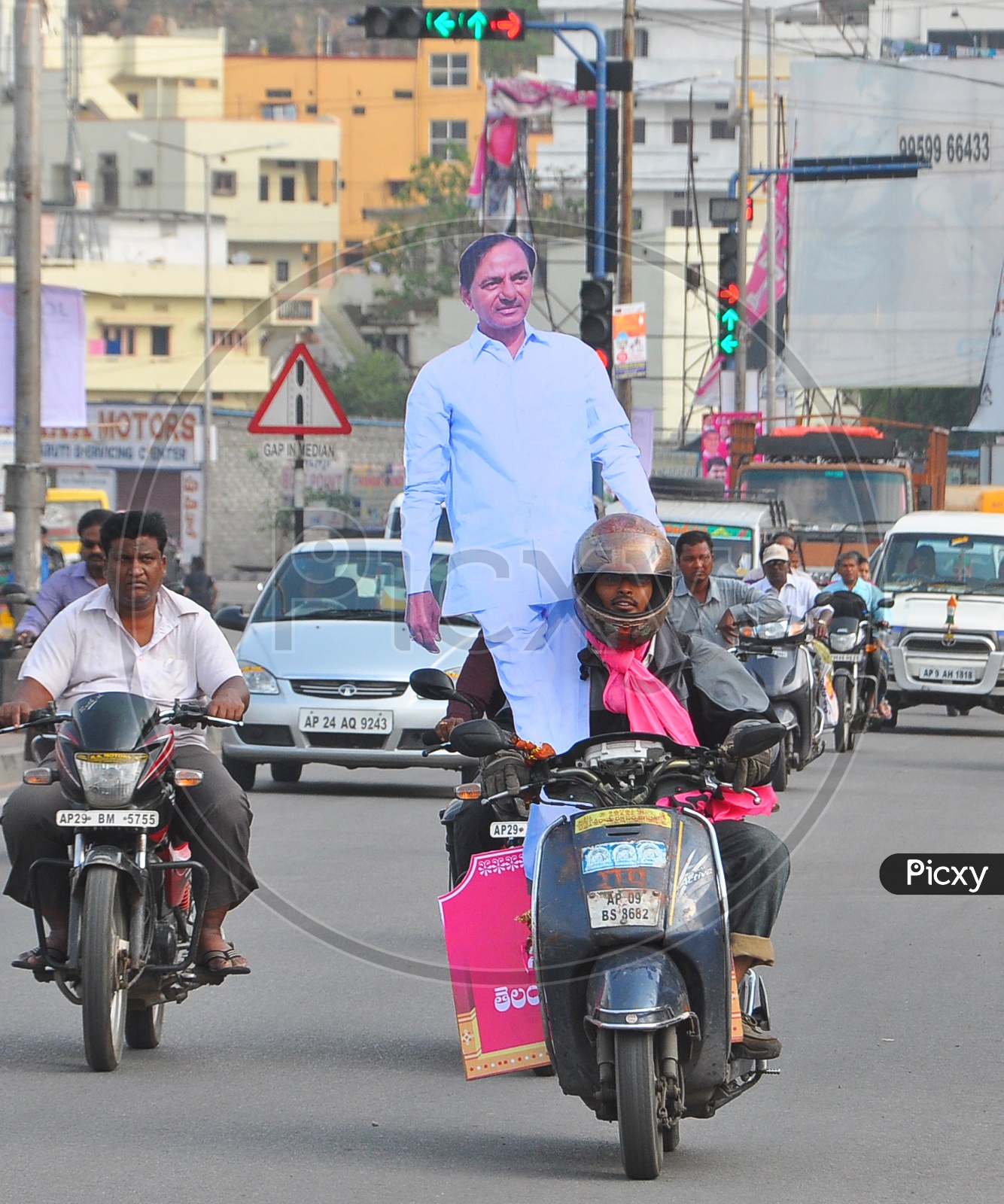 A TRS Supporter taking CM KCR Hoarding on Bike in Hyderabad