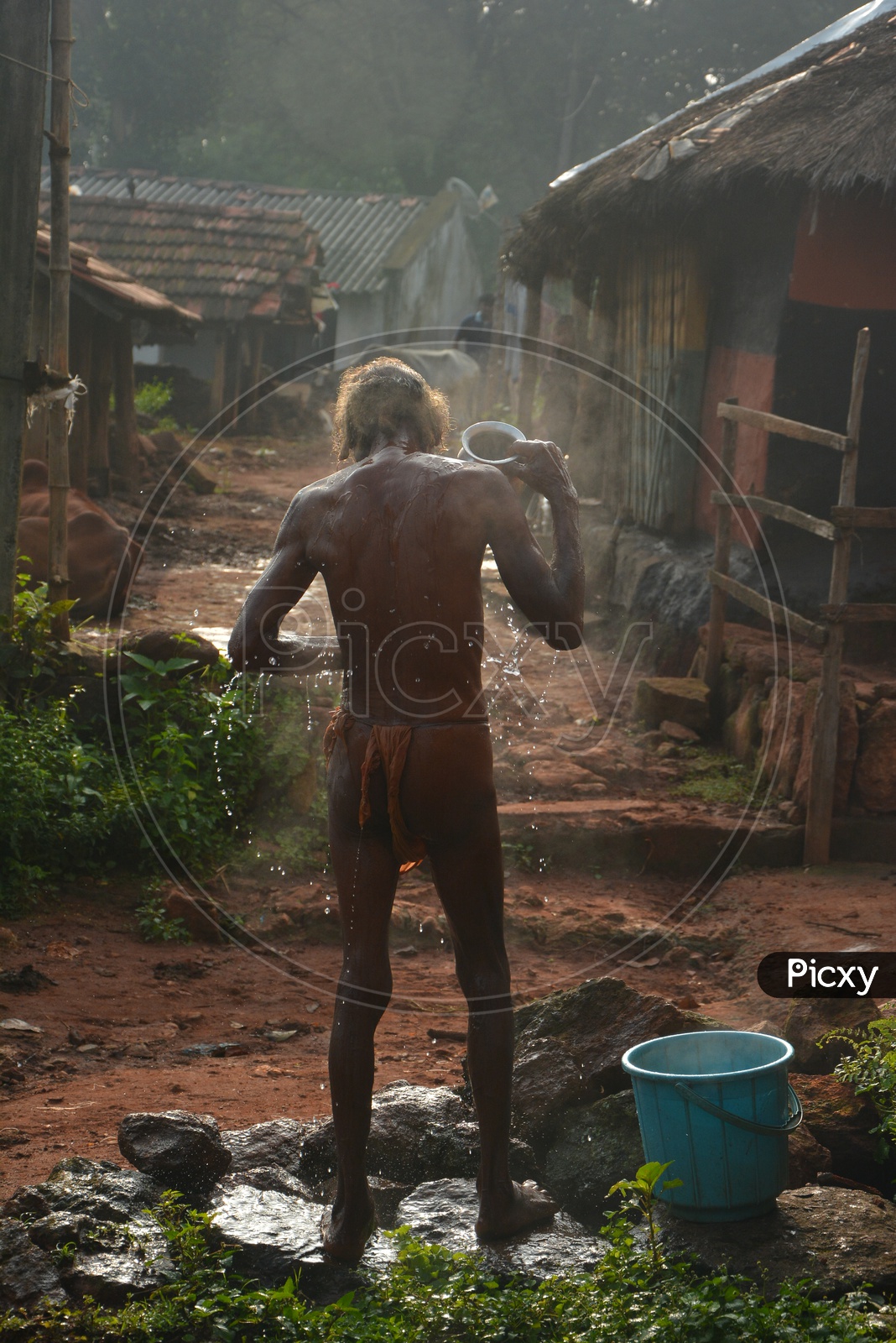 Image of Rural Indian Village Man bathing outside home-NI639840-Picxy