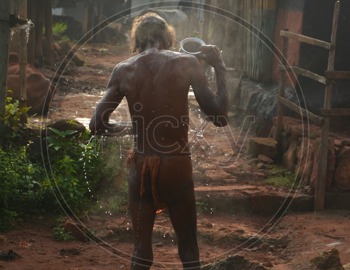 Rural Indian Village Man bathing outside home