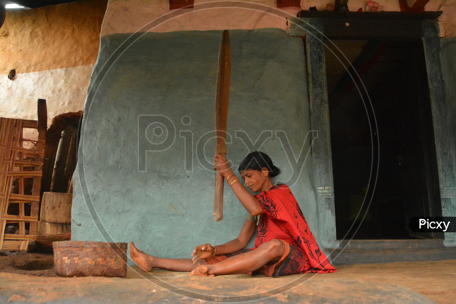 Tribal Woman making batter out of grains