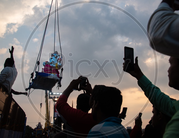 People trying to capture glimpses of their diety, Ganesh before immersion in their Smart Mobile Phones