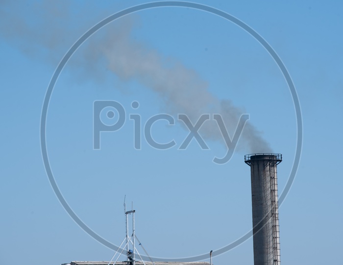 A Thick Black Smoke Coming Out Of a Industrial Exhaust Pipe from a Sugar Factory