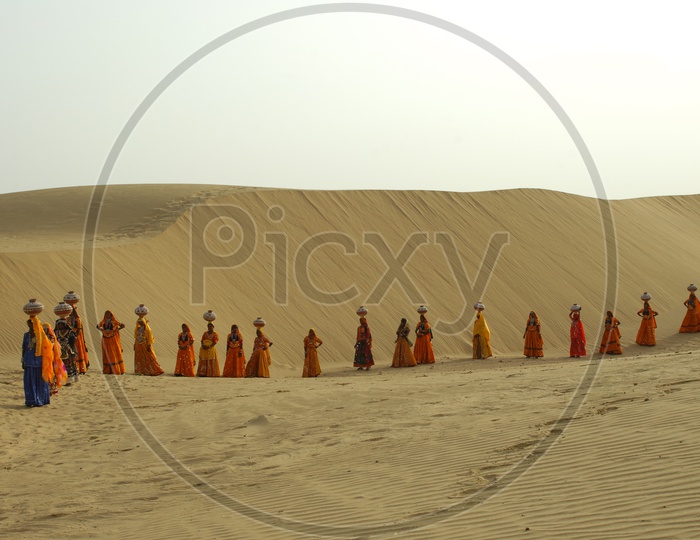 Indian Female with Pots on heads in Rajasthan desert