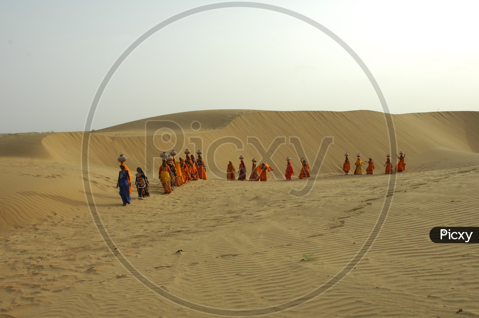 Rajasthani Women carrying water pots on their head in a Desert