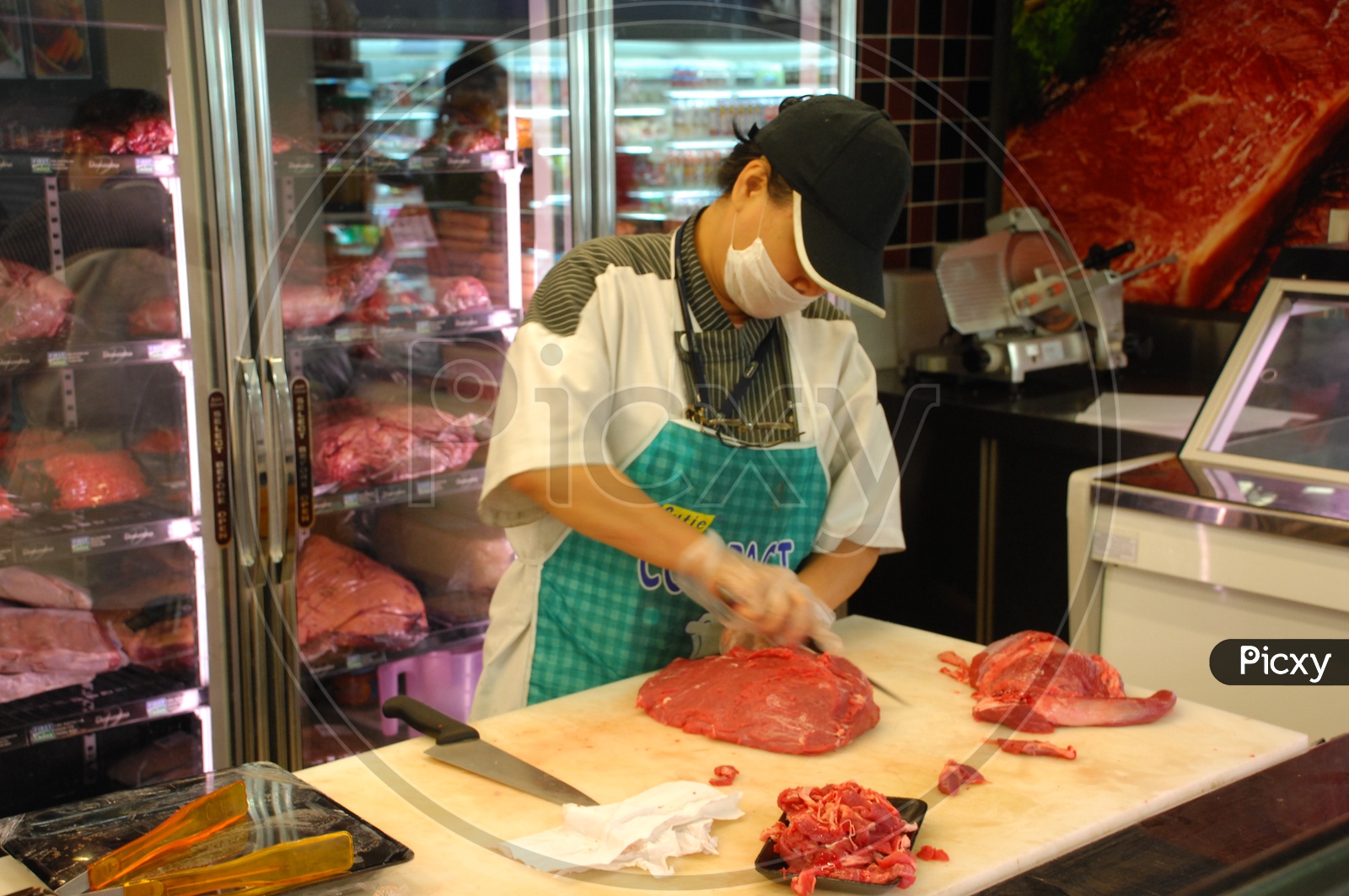 female butcher cutting meat