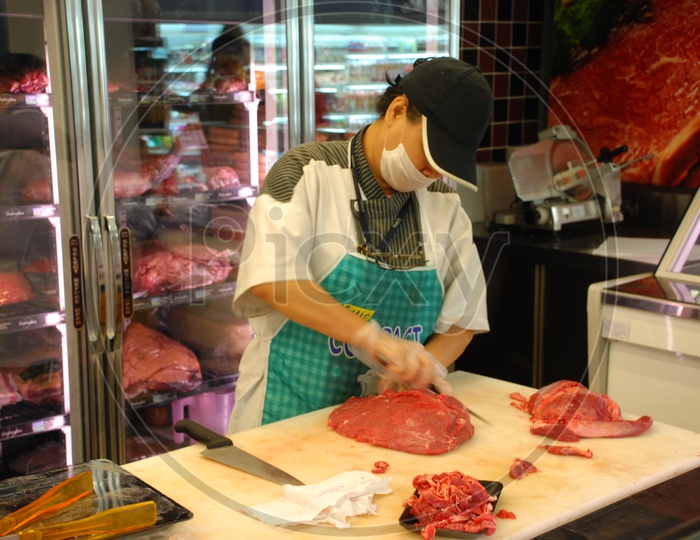 female butcher cutting meat