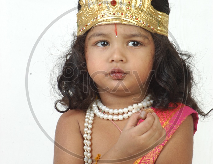 Indian Boy in Lord Sri Krishna Getup  and eating Chocolate Over an isolated White Background