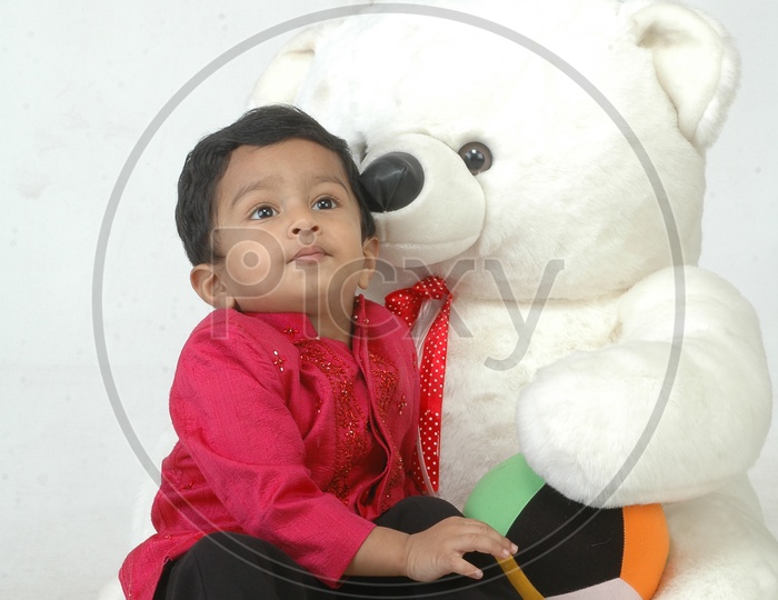 Indian Baby Boy Playing With a Teddy Bear Doll  Closeup Shot With Expressions On an Isolated White Background
