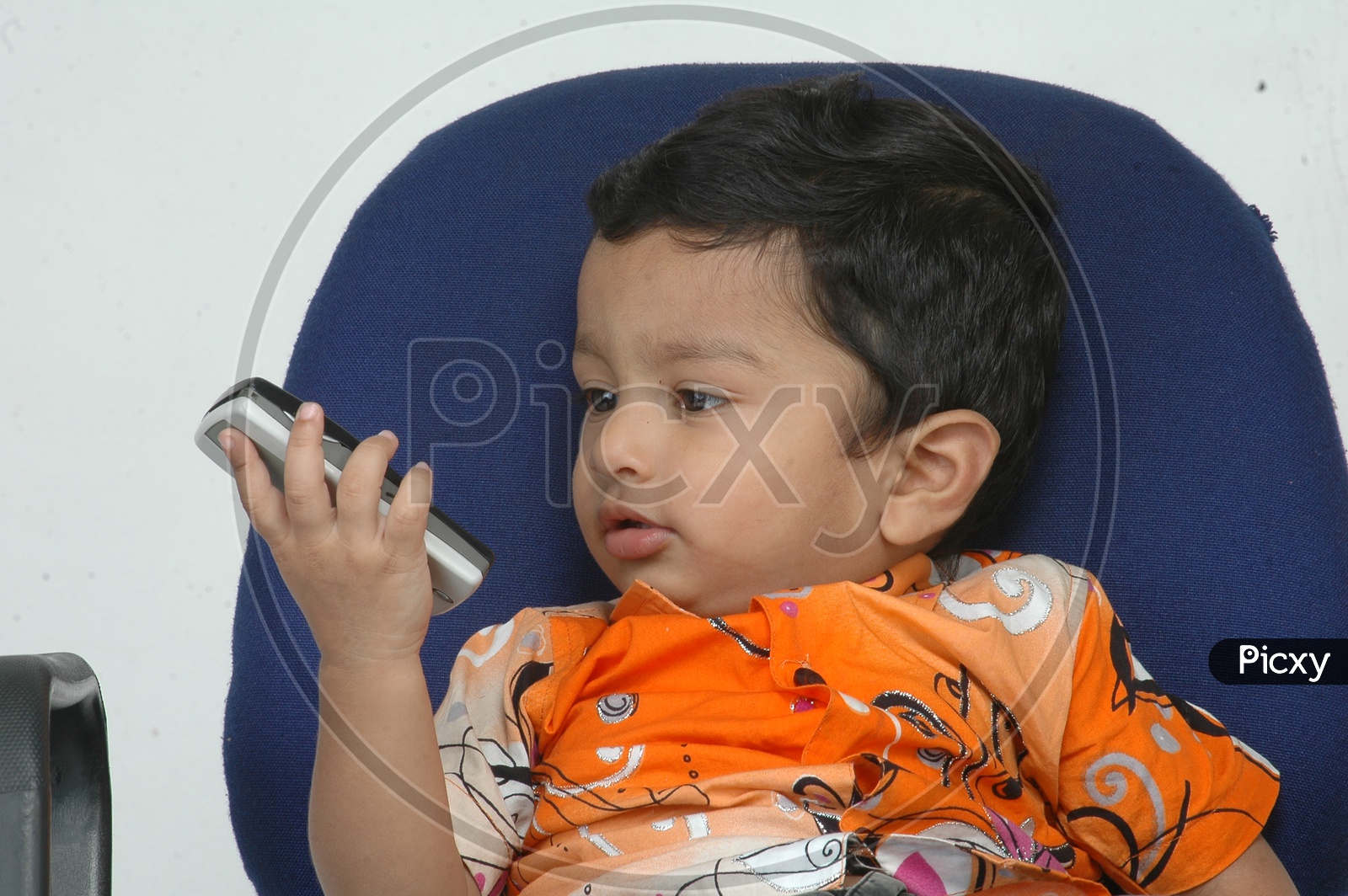 Indian Baby Boy Playing with Cellphone Closeup Shot On an Isolated White Background