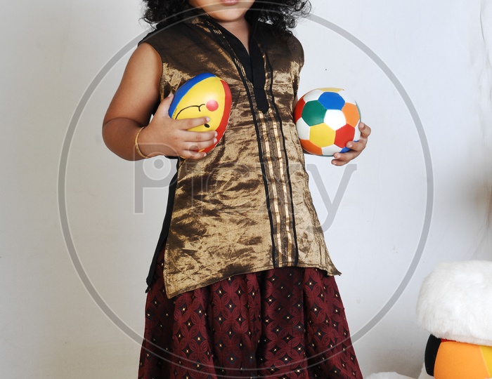 Indian Boy in Traditional Attire and With a Ball In Hand Over an Isolated White Background