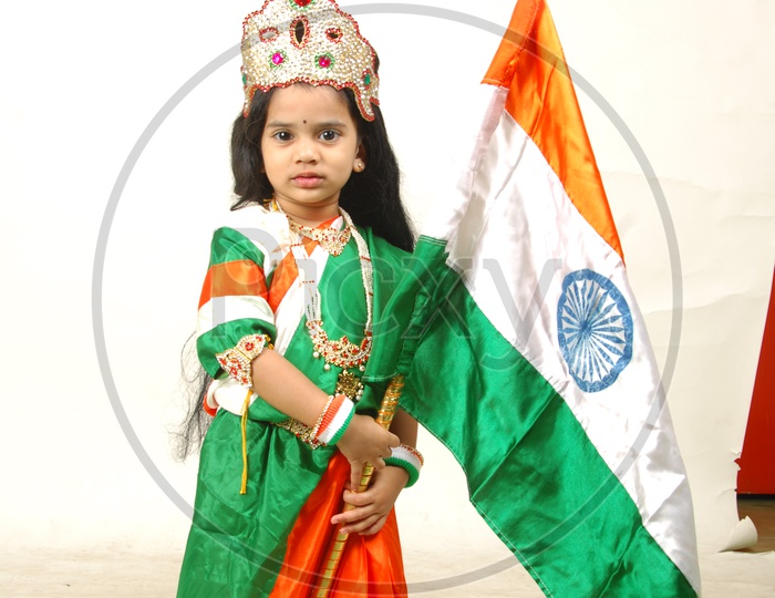 Indian Girl Child in Bharath Maatha Getup and Indian Flag over an Isolated White Background