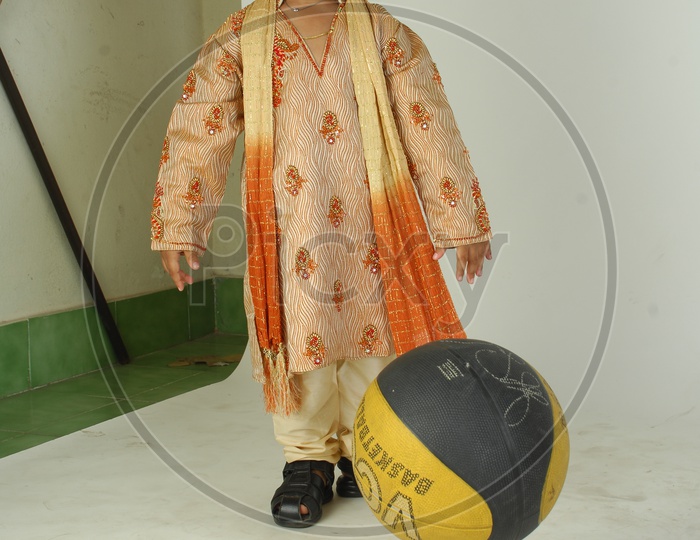 Indian Boy in Traditional Clothes With a Smiling Face  and With a Basketball in Hand  Over an Isolated White Background
