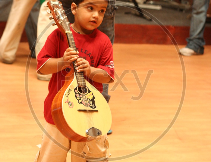 Indian Kid in a studio with a musical instrument
