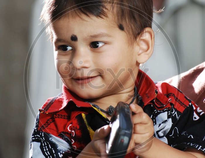 Indian Baby Boy Playing With a Cell Phone Closeup Shot