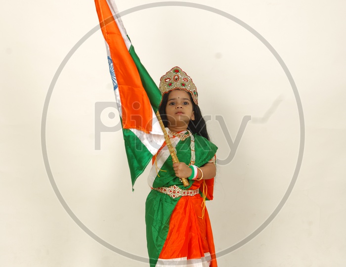Indian Girl Child in Bharath Maatha Getup and Indian Flag over an Isolated White Background