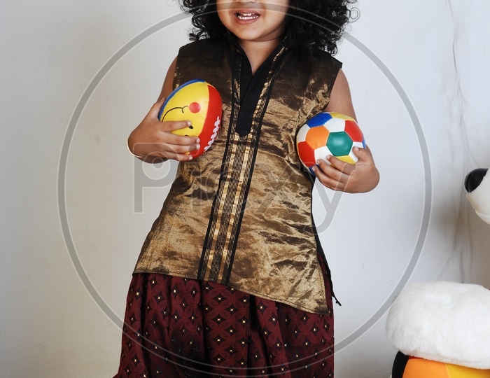 Indian Boy in Traditional Attire and With a Ball In Hand Over an Isolated White Background