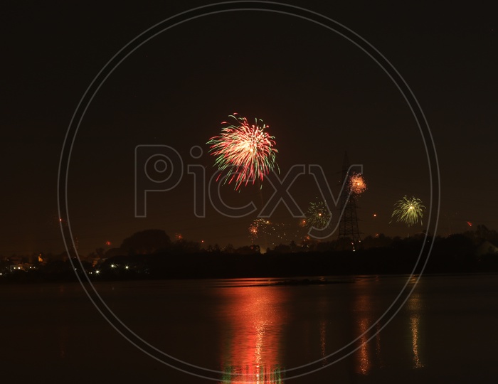 A Beautiful Long Exposure Shot Of a Diwali Crackers over a City View and Reflection on Water