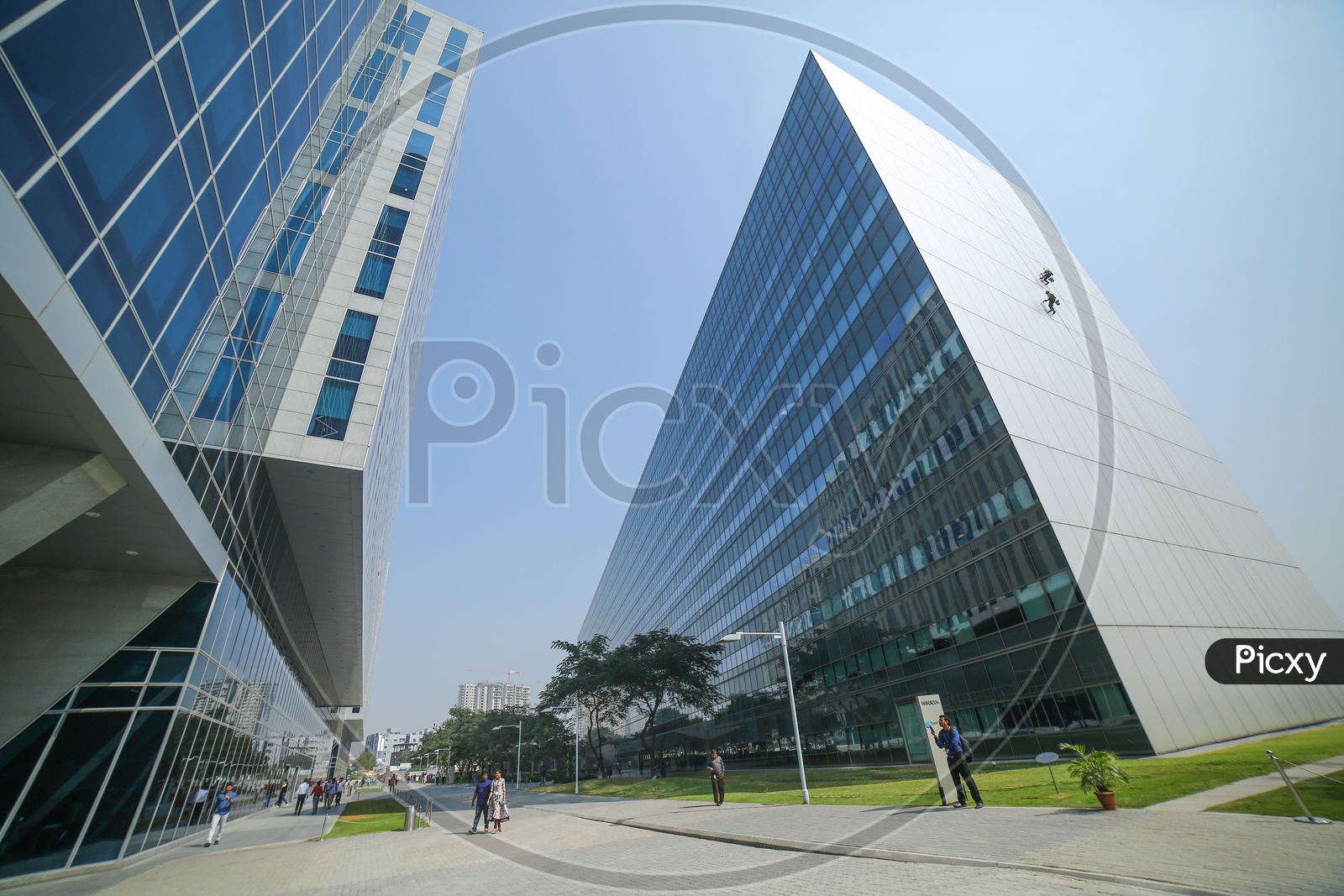 A Beautiful Architectural View Of WaveRock SEZ Building In Hyderabad with IT Employees walking in the Campus