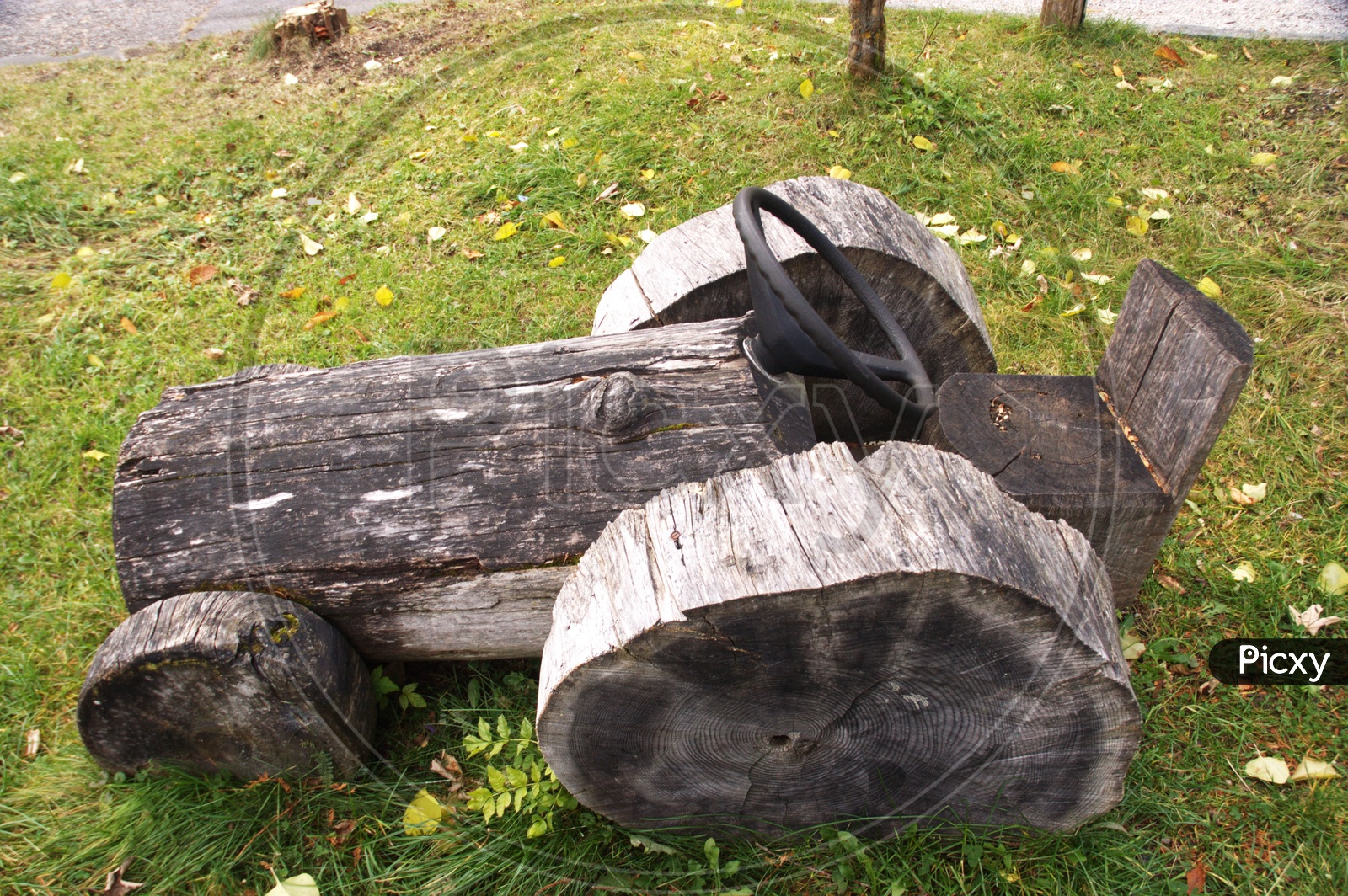A Tractor Model With Wood Logs In a Garden
