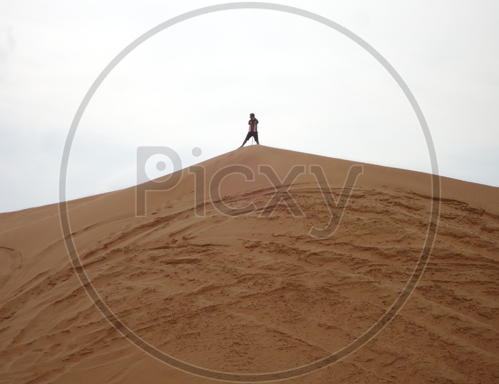 A Man Standing alone On  a Sand Dune In Desert