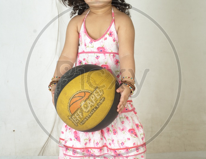 Indian Girl kid in a studio with basketball