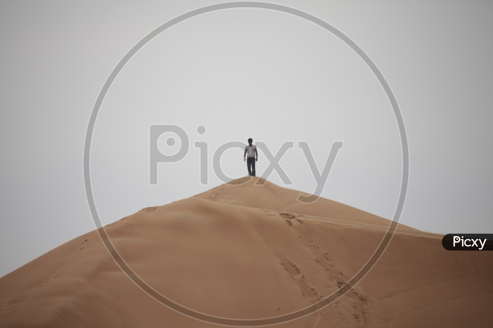 A Man Standing alone On  a Sand Dune In Desert