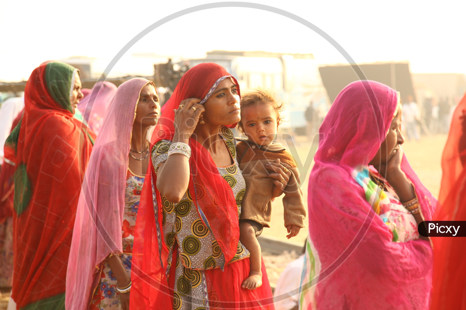 Indian Young Mother From Rajasthan Carrying her Child And Standing in a Queue Line