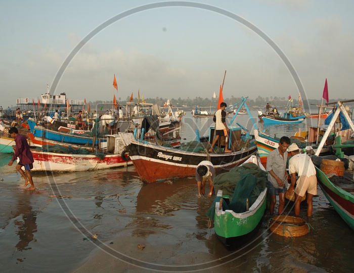 Fisher man With Their Fishing Boats on a River Bank