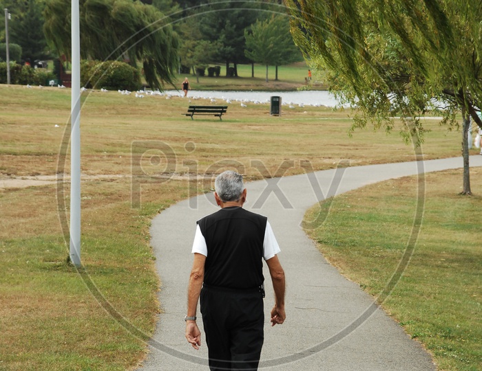 An Old Man walking On pathway as a Daily Routine Morning Walk