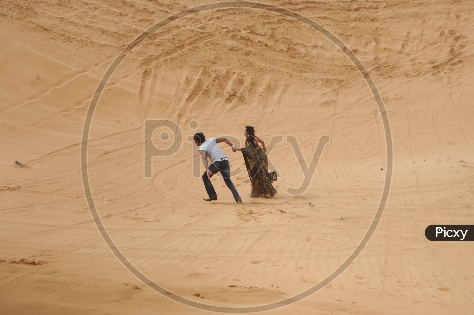 Indian Couple Holdinf Hands and Running In Desert