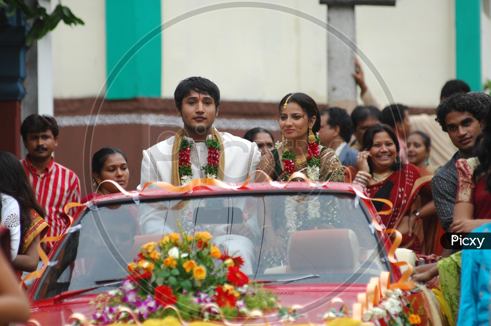 Indian Wedding baraat with bride and groom in car