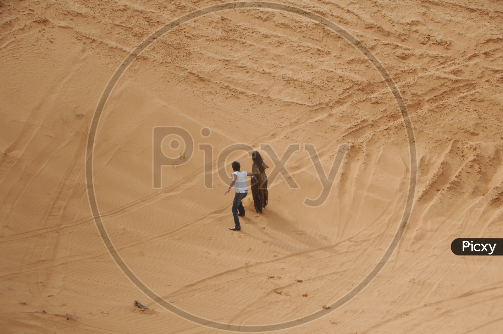 Indian Couple Holdinf Hands and Running In Desert