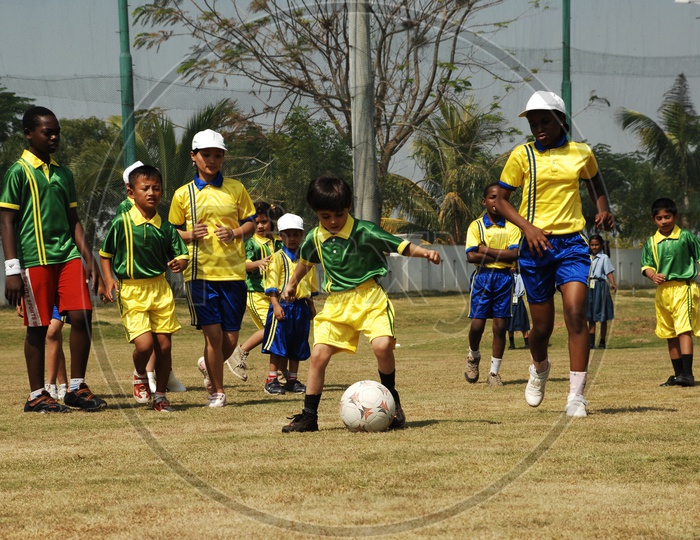 Children playing football in uniform