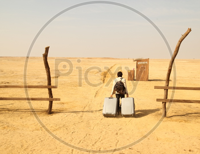 A Traveller With his trolley Luggage in Desert