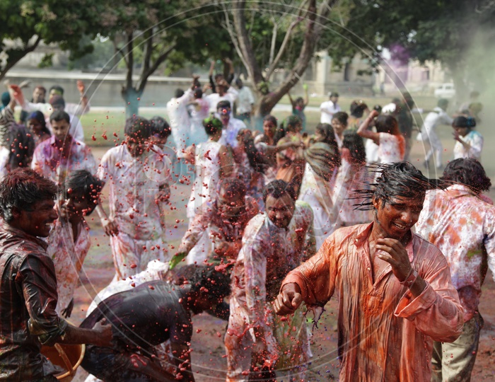 People celebrating holi festival / People throwing colors to each other during the Holi celebration in Hyderabad