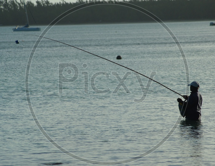 A Fisherman Fishing With a Fishing Rod