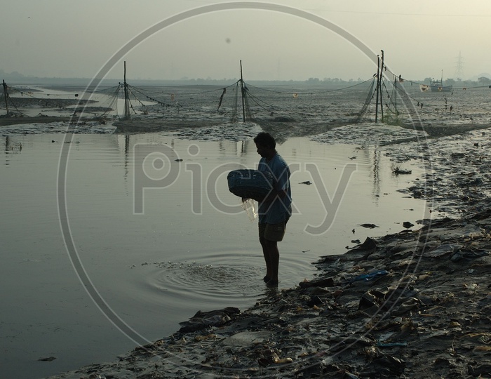 A Fisher man With His Catch of Fish Carrying in a basket
