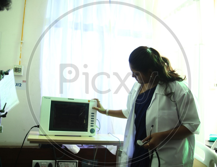 A Doctor Checking The patient Monitoring equipment in Hospital