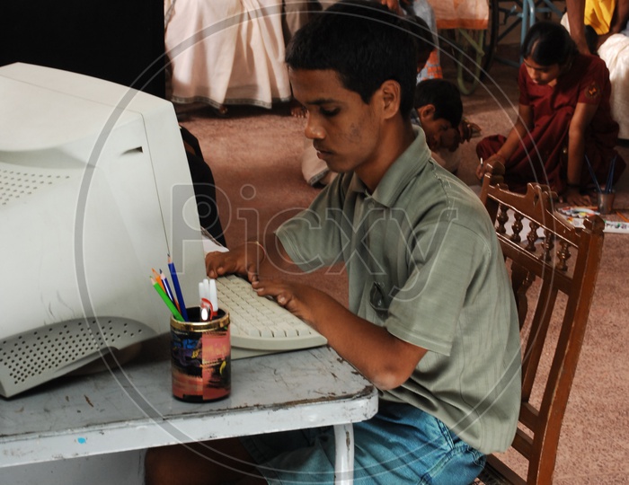 A Differently abled Child Working On a Computer