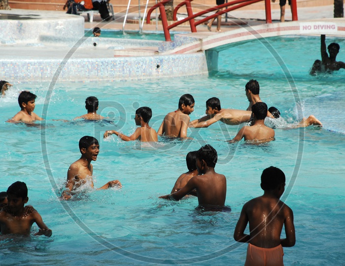 Children and men Playing in the swimming pool at a Water park